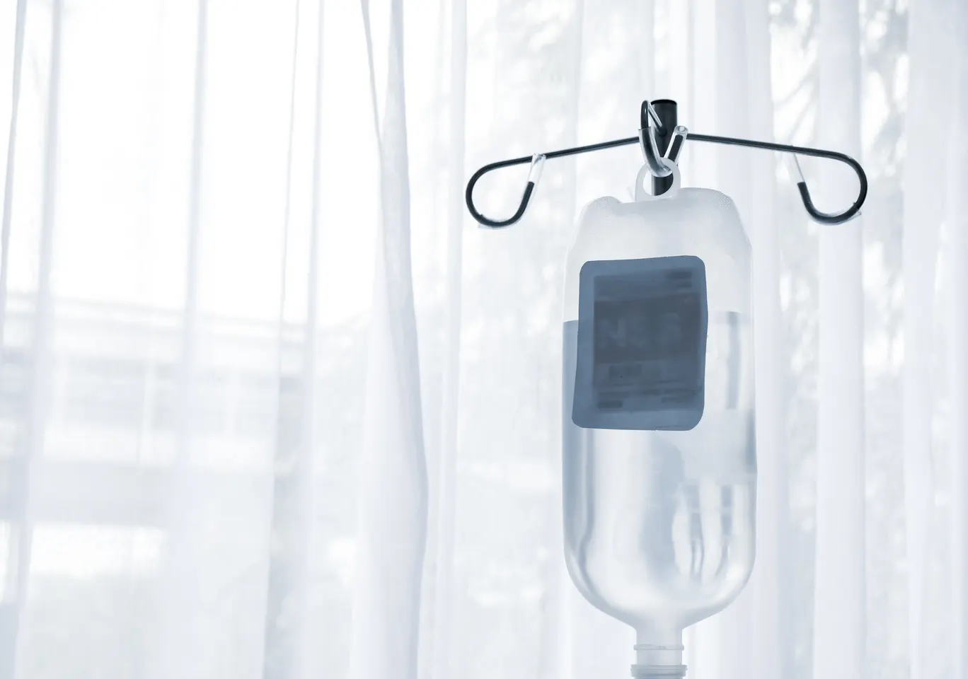 Kroplówki witaminowe Człuchów: butelka płynu infuzyjnego zawieszona przy oknie